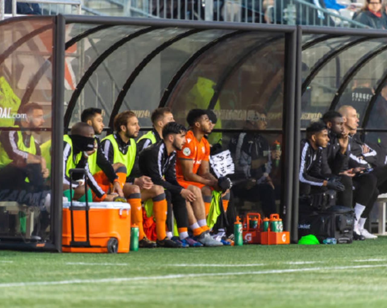 Players sitting on bench watching match