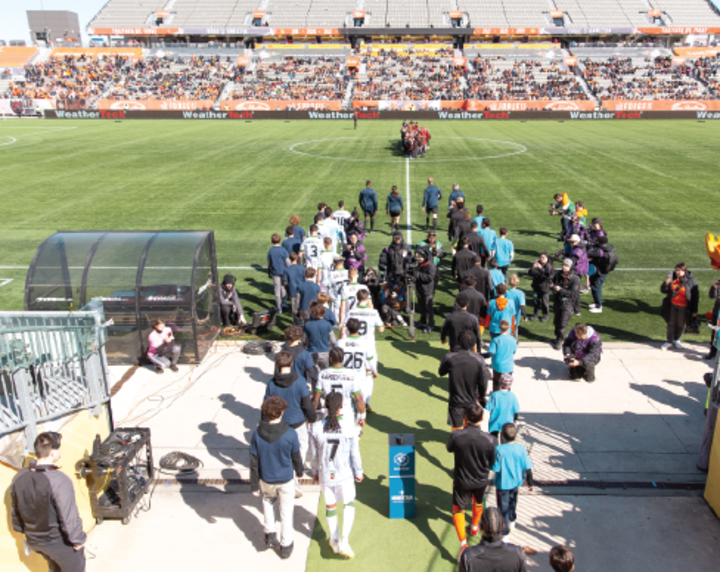 Players escorting fans onto field pre-match